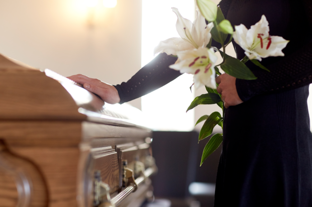 Woman with flowers at casket